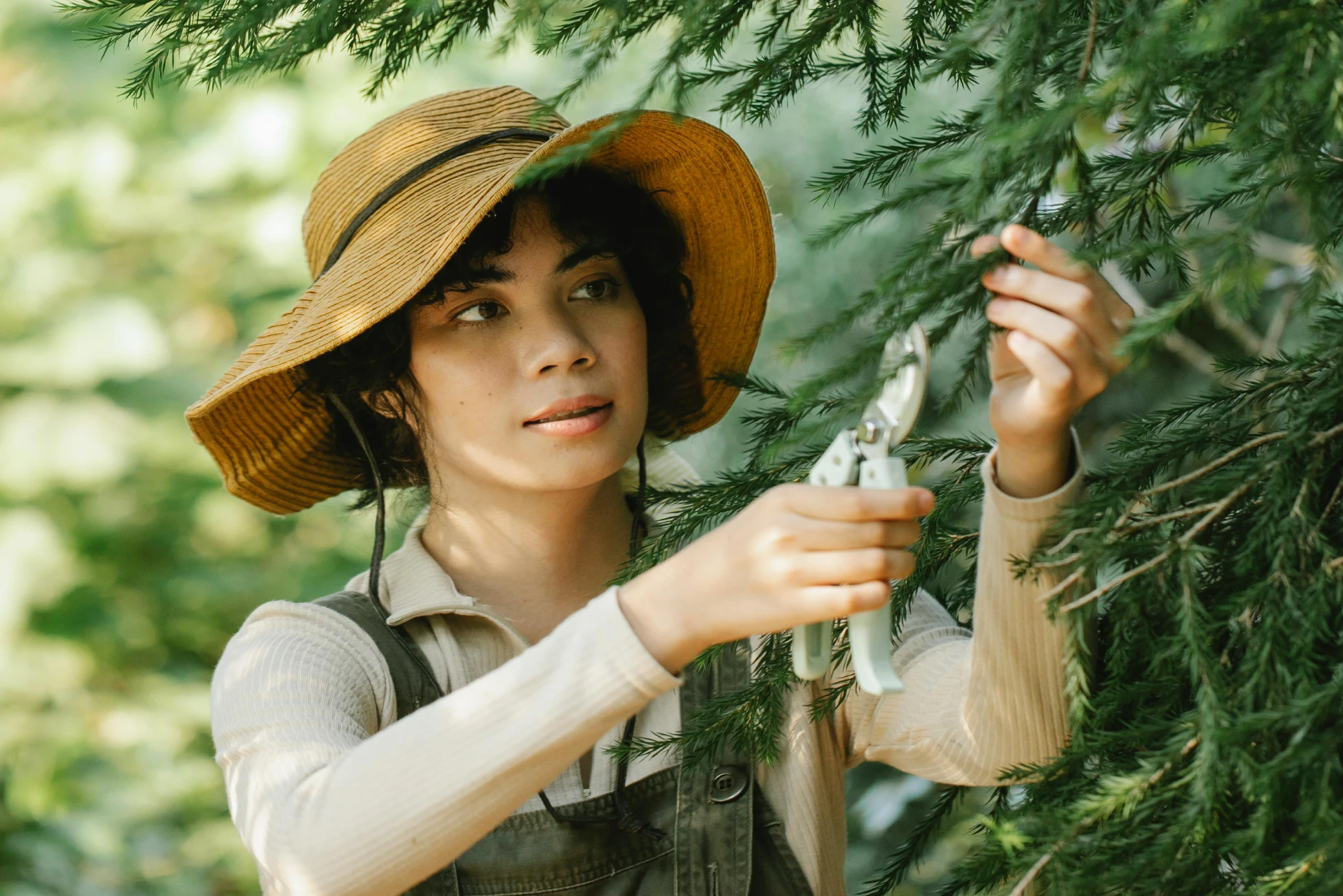 Woman studying a small bird in a forest setting.